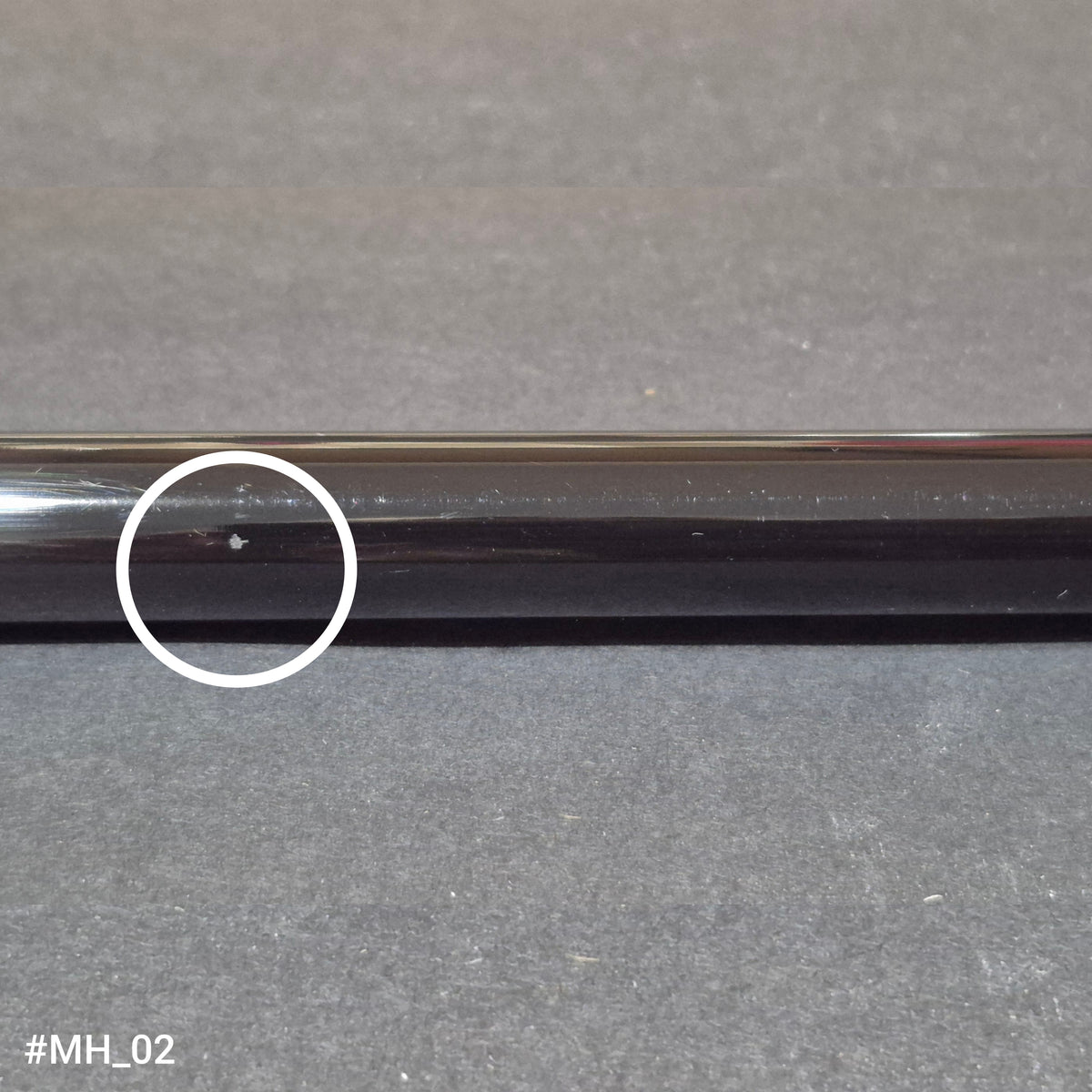 A discounted RamRods Matterhorn archery stabilizer, tungsten damping, 30 inch. A chip in the shaft surface is circled in white.
