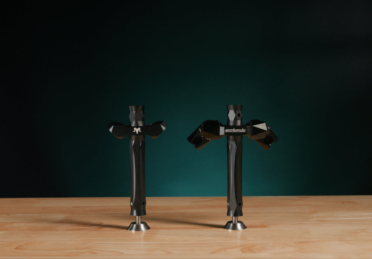 Photo of a fixed V-Bar and adjustable V-Bar attached to extensions, sitting on a table. 