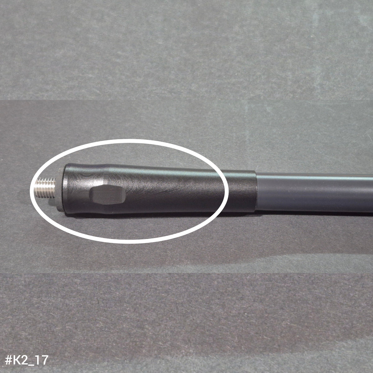 A RamRods archery stabilizer, K2 2 series, 15 inch length. A marble-like pattern on the surface of an end cap is circled in white.